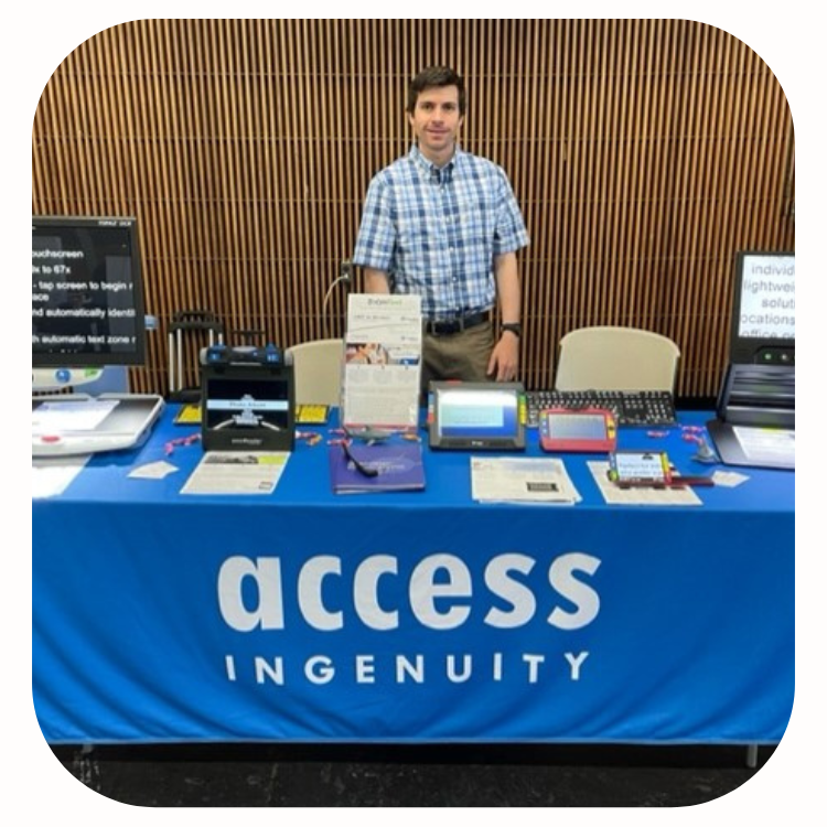 Michael Vitagliano standing behind Access Ingenuity table