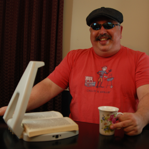 Man sitting at table using the LyriQ Reader