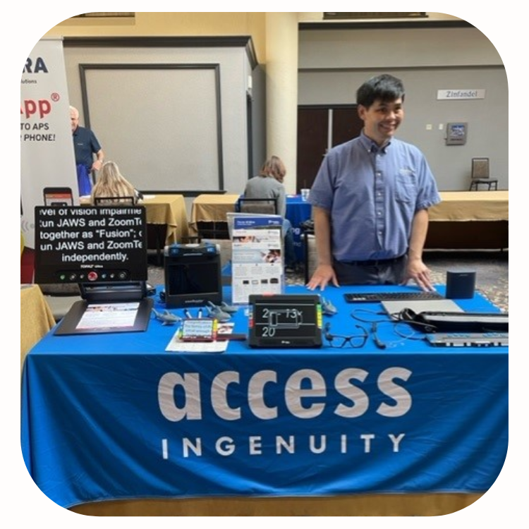 Zhi Huang standing behind Access Ingenuity table