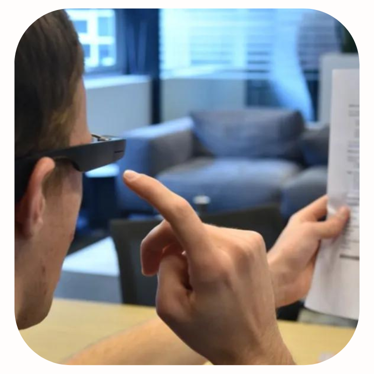 Man swiping Envision glasses and holding paper