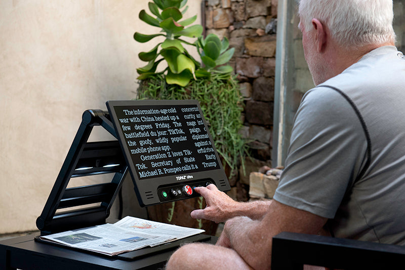 man magnifying newspaper and displaying white text on black background with TOPAZ® Ultra